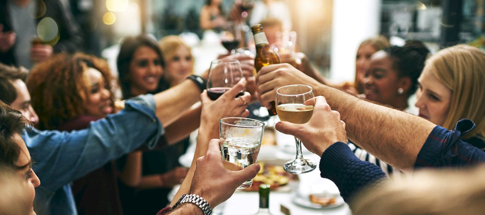 A group of people clinking glasses in a toast, celebrating together.