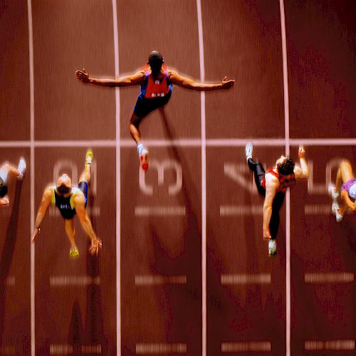 Aerial view of six sprinters crossing the finish line on a track, with arms outstretched and legs extended in mid-stride.